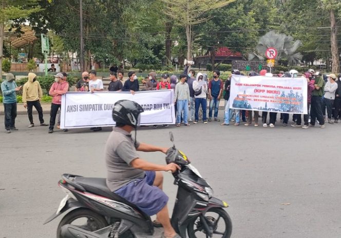 
 Sejumlah massa menggelar aksi simpatik di jalan untuk menyuarakan dukungan terhadap RUU TNI. Sementara itu, pengendara motor tetap melintas, mencerminkan dinamika antara aspirasi publik dan aktivitas sehari-hari. Foto: Istimewa 