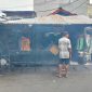Seorang penjual sate di depan warung sederhana menunjukkan semangat kerja di tengah kondisi ekonomi yang terbatas. Aktivitas sehari-hari seperti ini menjadi cerminan perjuangan masyarakat untuk mencukupi kebutuhan hidup.