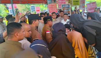 Gubernur Sulawesi Tengah Anwar Hafid berdialog dengan warga saat aksi damai penolakan tambang di Jalan Malonda, Ulujadi, Kota Palu, Selasa, 10 Juni 2025. Dalam aksi jilid kedua ini, warga dari Desa Tipo, Kalora, dan Kinovaro menuntut pencabutan izin tambang yang dianggap merusak lingkungan dan berpotensi memicu konflik sosial. Foto: Tim PaluPoso