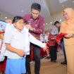 Bupati Parigi Moutong, Erwin Burase, didampingi istri, Hesti, mengenakan seragam kepada siswa dalam peluncuran program Seragam Sekolah Gratis, Rabu (24/7/2025) Foto: Diskominfo Parimo 