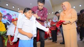 Bupati Parigi Moutong, Erwin Burase, didampingi istri, Hesti, mengenakan seragam kepada siswa dalam peluncuran program Seragam Sekolah Gratis, Rabu (24/7/2025) Foto: Diskominfo Parimo 