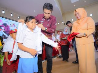 Bupati Parigi Moutong, Erwin Burase, didampingi istri, Hesti, mengenakan seragam kepada siswa dalam peluncuran program Seragam Sekolah Gratis, Rabu (24/7/2025) Foto: Diskominfo Parimo 