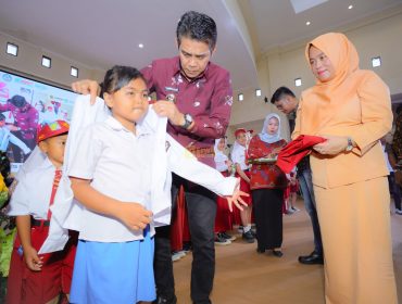Bupati Parigi Moutong, Erwin Burase, didampingi istri, Hesti, mengenakan seragam kepada siswa dalam peluncuran program Seragam Sekolah Gratis, Rabu (24/7/2025) Foto: Diskominfo Parimo 