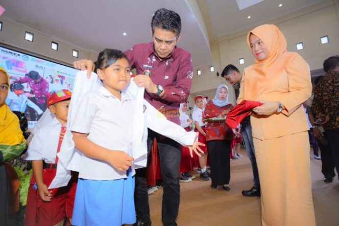 
 Bupati Parigi Moutong, Erwin Burase, didampingi istri, Hesti, mengenakan seragam kepada siswa dalam peluncuran program Seragam Sekolah Gratis, Rabu (24/7/2025) Foto: Diskominfo Parimo 