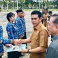 Bupati Parigi Moutong Erwin Burase menyerahkan SK pengangkatan kepada perwakilan PPPK dan CPNS di Halaman Kantor Bupati, 8 Juli 2025.
Foto: Dokumentasi Humas Pemkab Parimo