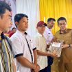 Bupati Parigi Moutong, Erwin Burase, menyerahkan akta dan SK badan hukum kepada perwakilan Koperasi Merah Putih secara simbolis. Foto: Diskominfo Parimo 