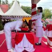 Momen haru Wali Kota Palu mencium Sang Saka Merah Putih sebelum penyerahan bendera pusaka kepada Paskibraka pada upacara peringatan HUT ke-80 Kemerdekaan Republik Indonesia, Minggu (17/8/2025). Foto: Pemkot Palu 
