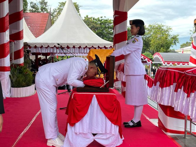 
 Momen haru Wali Kota Palu mencium Sang Saka Merah Putih sebelum penyerahan bendera pusaka kepada Paskibraka pada upacara peringatan HUT ke-80 Kemerdekaan Republik Indonesia, Minggu (17/8/2025). Foto: Pemkot Palu 

