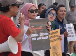 Jurnalis Sulteng di Palu membentangkan poster dalam aksi mimbar bebas menolak gugatan Menteri Pertanian terhadap Tempo yang dinilai mengancam kebebasan pers, Minggu (16/11/2025). Foto: Istimewa