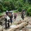 Petugas kepolisian membantu evakuasi warga, termasuk anak-anak, melintasi jalur terdampak banjir dan longsor di wilayah Donggala. Foto: Tim Gubernur Sulteng 