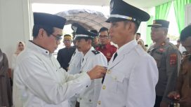 Bupati Parigi Moutong Erwin Burase menyematkan tanda jabatan kepada kepala desa antar waktu saat pelantikan di Kabupaten Parigi Moutong, Selasa (10/3/2026). Foto: Pemda Parigi Moutong 