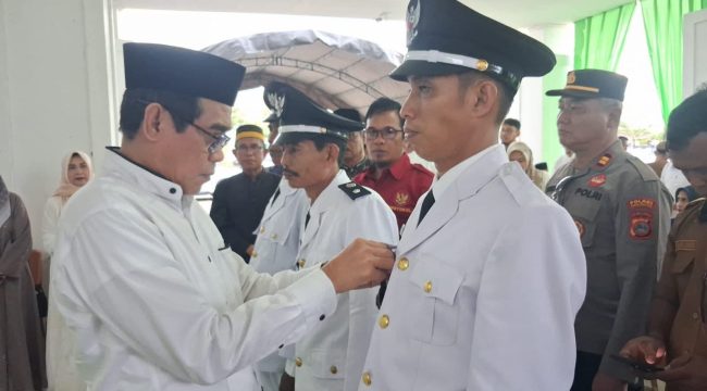 Bupati Parigi Moutong Erwin Burase menyematkan tanda jabatan kepada kepala desa antar waktu saat pelantikan di Kabupaten Parigi Moutong, Selasa (10/3/2026). Foto: Pemda Parigi Moutong 