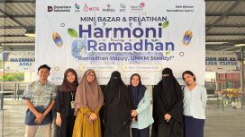 Peserta dan panitia berfoto bersama di depan backdrop Harmoni Ramadan 2026 usai mini bazar dan pelatihan UMKM di Kantor Telkom Palu. Foto: Dok. Telkom 