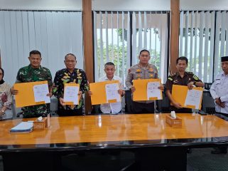 Wali Kota Palu Hadianto Rasyid bersama unsur Forkopimda menunjukkan dokumen nota kesepahaman usai penandatanganan kerja sama penguatan pengawasan pajak daerah di ruang kerja Wali Kota Palu, Jumat (13/3/2026). Foto: Dok. Pemkot Palu 