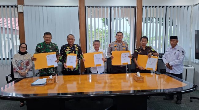 Wali Kota Palu Hadianto Rasyid bersama unsur Forkopimda menunjukkan dokumen nota kesepahaman usai penandatanganan kerja sama penguatan pengawasan pajak daerah di ruang kerja Wali Kota Palu, Jumat (13/3/2026). Foto: Dok. Pemkot Palu 