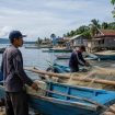 Ilustrasi nelayan di desa pesisir pagi hari. Foto: PPID/AI