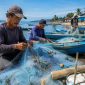Nelayan memperbaiki pukat di kawasan pesisir